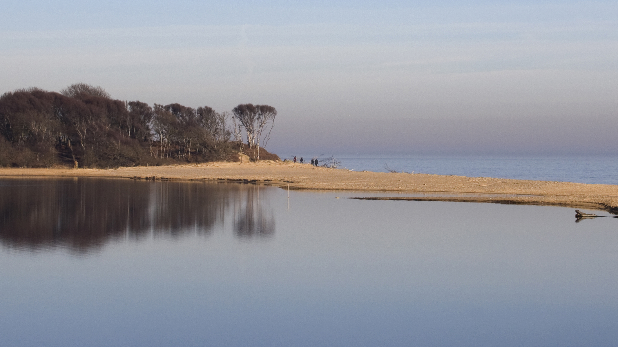 a landscape view of a beach with a small strip separating it from a saline lagoon